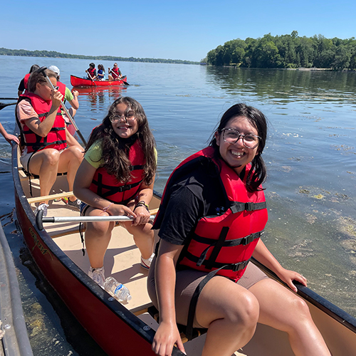 Three kids in a canoe on Lake Waubesa