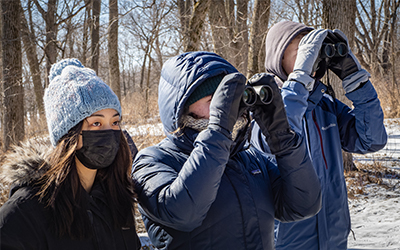 Students looking through binoculars, bundled up for the winter